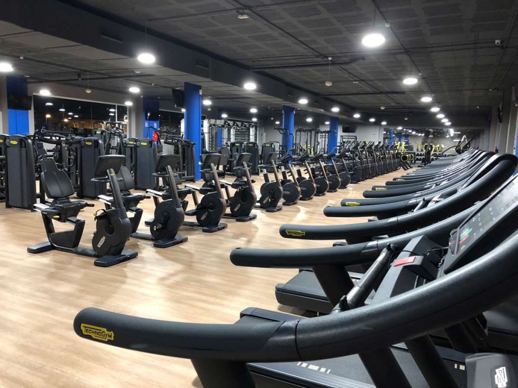 Sala de gimnasio con máquinas de correr y bicis estáticas