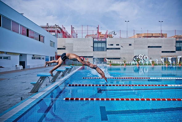 Nadadores tirándose en una piscina olímpica